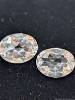 Close-up of two white topaz gemstones showing facets