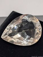 Top view of pear-shape faceted white topaz on black background