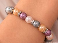 Bracelet on wrist showing multicolor pearls and rhinestone spacers