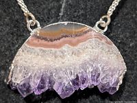 Close-up of agate/quartz pendant showing crystal formation and silver setting