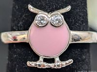 Front view of owl ring showing pink enamel body and CZ eyes