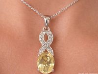 Close-up of sterling silver pendant with lemon quartz center stone and CZ accents on chain