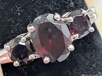 Front view showing three garnet stones and prong setting