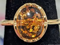 Front view of ring showing amber cabochon and setting