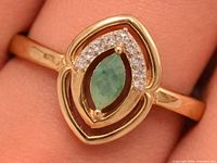 Front view of emerald ring on finger