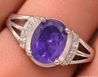 Top view of silver ring with oval amethyst and accent stones