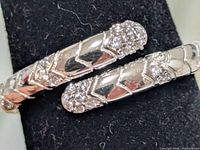 Close-up of silver ring showing chevron link design and cubic zirconia accents