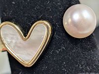 Close-up of heart-shaped mother-of-pearl inlay and adjacent pearl