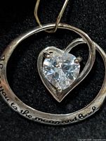 Front view of silver pendant showing heart-cut CZ and engraving