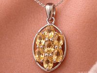 Pendant on chain showing front view, oval cluster of citrines