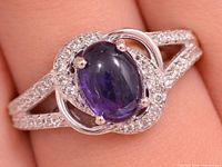 Top view of ring showing amethyst cabochon, CZ halo, split shank