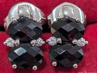 Close-up of both silver garnet stud earrings showing gemstones and setting