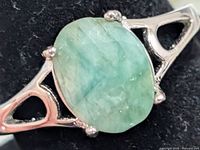 close-up of emerald cabochon and silver setting