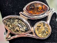 Front view of silver ring showing green, cognac and yellow amber stones