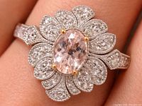 Ring worn on finger showing morganite and CZ halo design