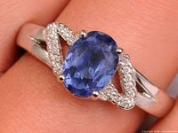 Front view of silver ring showing sapphire and accent stones