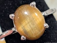 Close-up of sterling silver ring featuring oval tiger's eye stone