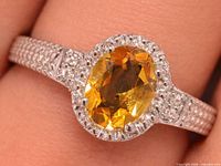 Top view showing oval citrine, halo of clear stones and textured band