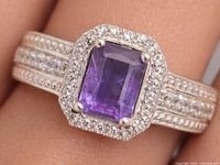 Front view of sterling silver ring with amethyst center and CZ halo on triple-row CZ shank