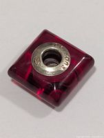 Top view of square pink glass bead showing silver core and hallmarks