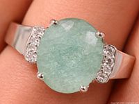 Front view of sterling silver ring with green oval stone and side accents