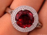 Ring on finger showing created ruby centre stone and CZ halo