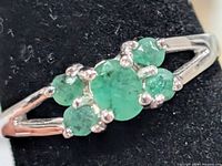 Top view of sterling silver ring with emerald cluster