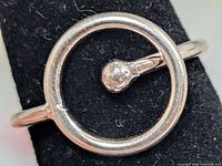 Front view of silver ring showing open circle and ball accent