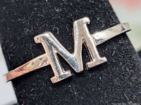 Front view of silver ring with letter M