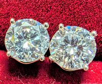close-up of both diamond studs showing cut and prong settings