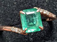 Front view showing emerald-cut emerald and diamond-accented shoulders