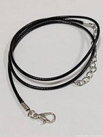 Coiled black cord necklace chain showing lobster clasp and extension chain