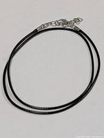Full view of black cord necklace with clasp and extender
