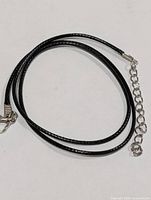 Coiled black cord necklace showing clasp and extender