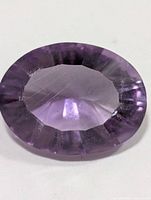 Top view of oval faceted purple amethyst showing facets and clarity