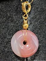 Front view of pink agate donut pendant showing stone color and wire wrap