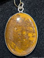 Front view of oval ocean jasper pendant in sterling bezel