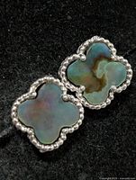 Front view of both earrings showing mother of pearl inlays and silver beaded borders