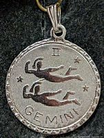 front view of round silver Gemini pendant