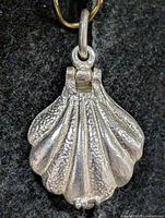 Front view of silver scallop shell locket pendant