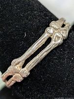Front view of silver bone motif ring on display mandrel