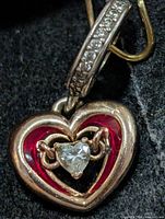 Front view of sterling silver heart pendant with red enamel and heart-shaped CZ, bail set with small CZ