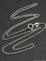 Silver cable-link chain laid out to show overall length and links