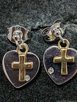 front view of both earrings showing heart shape, gold cross overlay, diamond accent and 925 stamp on backs