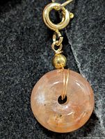 Front view of peach stone pendant with clasp
