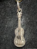 Front view of silver guitar pendant
