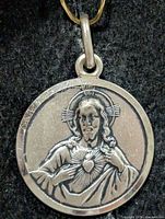 Front view of silver pendant showing Sacred Heart of Jesus design