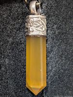 Front view of yellow aventurine pencil pendant showing silver cap and point