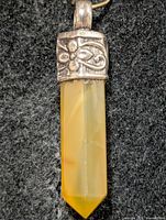 Front view of yellow aventurine pendant showing silver floral cap and faceted crystal