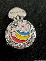 Front view showing enamel rainbow, flowers, rhinestone border